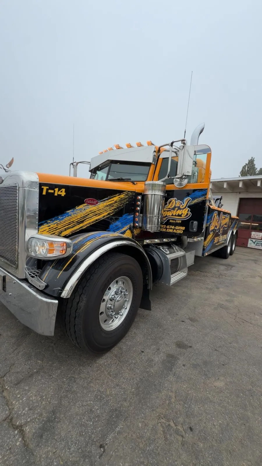 D&J Towing T-14 heavy-duty wrecker in the D&J wrap at the yard