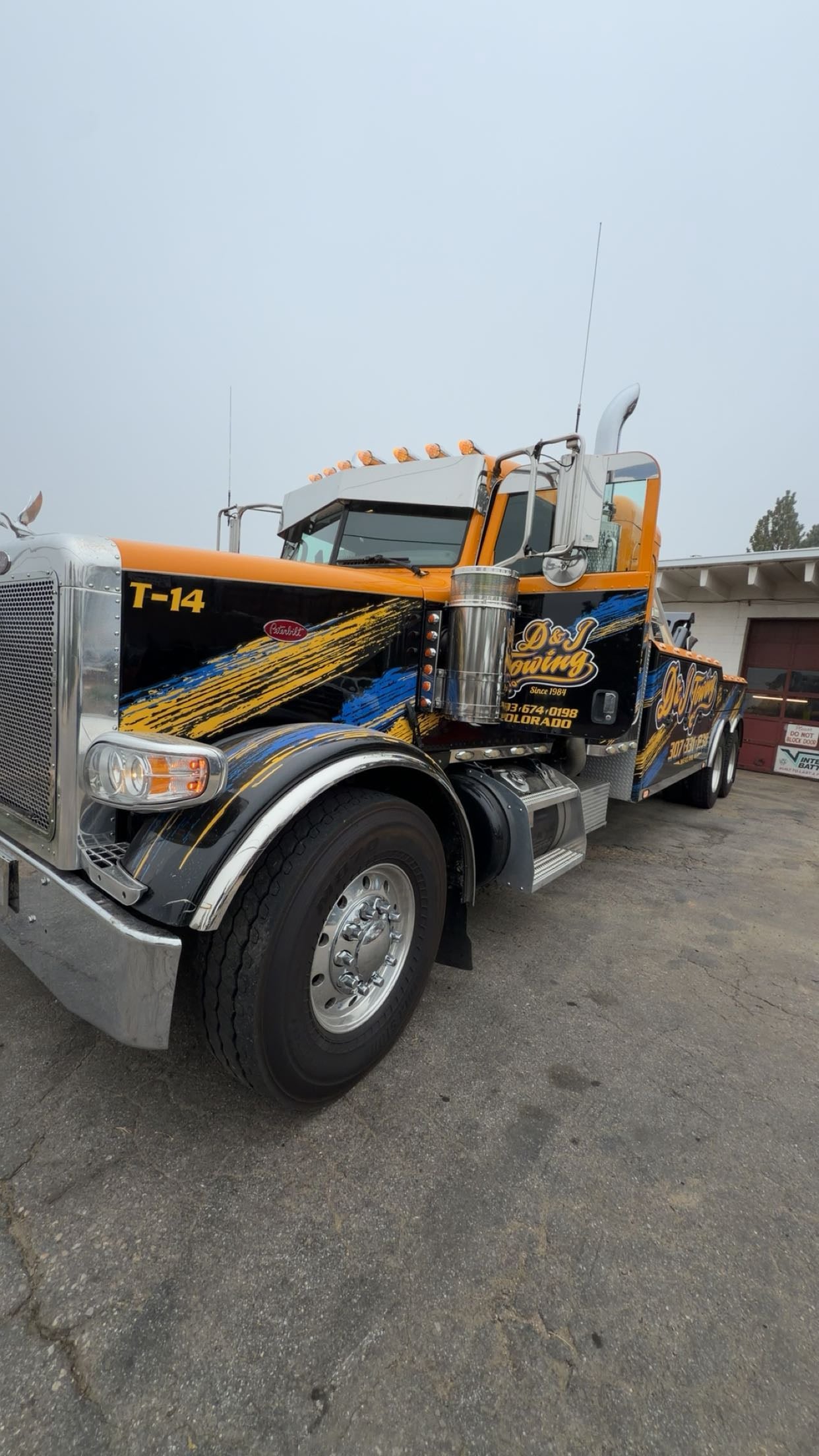 D&J Towing T-14 heavy-duty wrecker in the D&J wrap at the yard