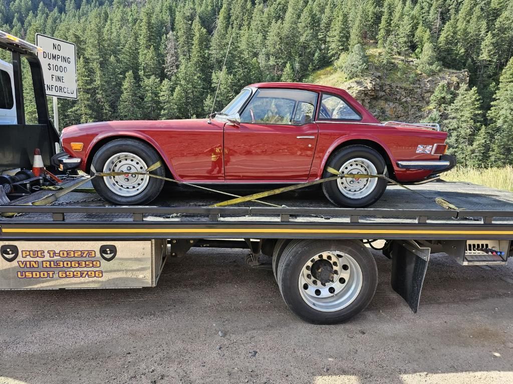 Red classic car loaded on a flatbed tow truck, wide view