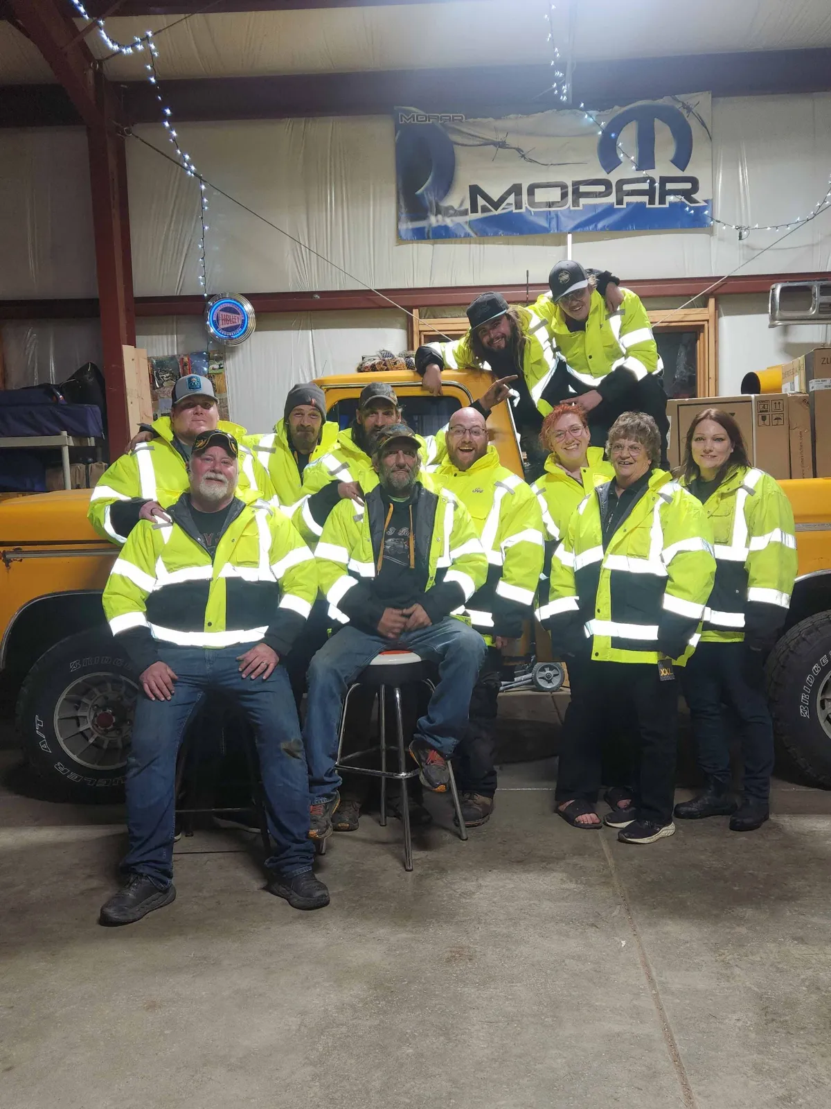 The D&J Towing crew in high-visibility jackets in front of a tow truck
