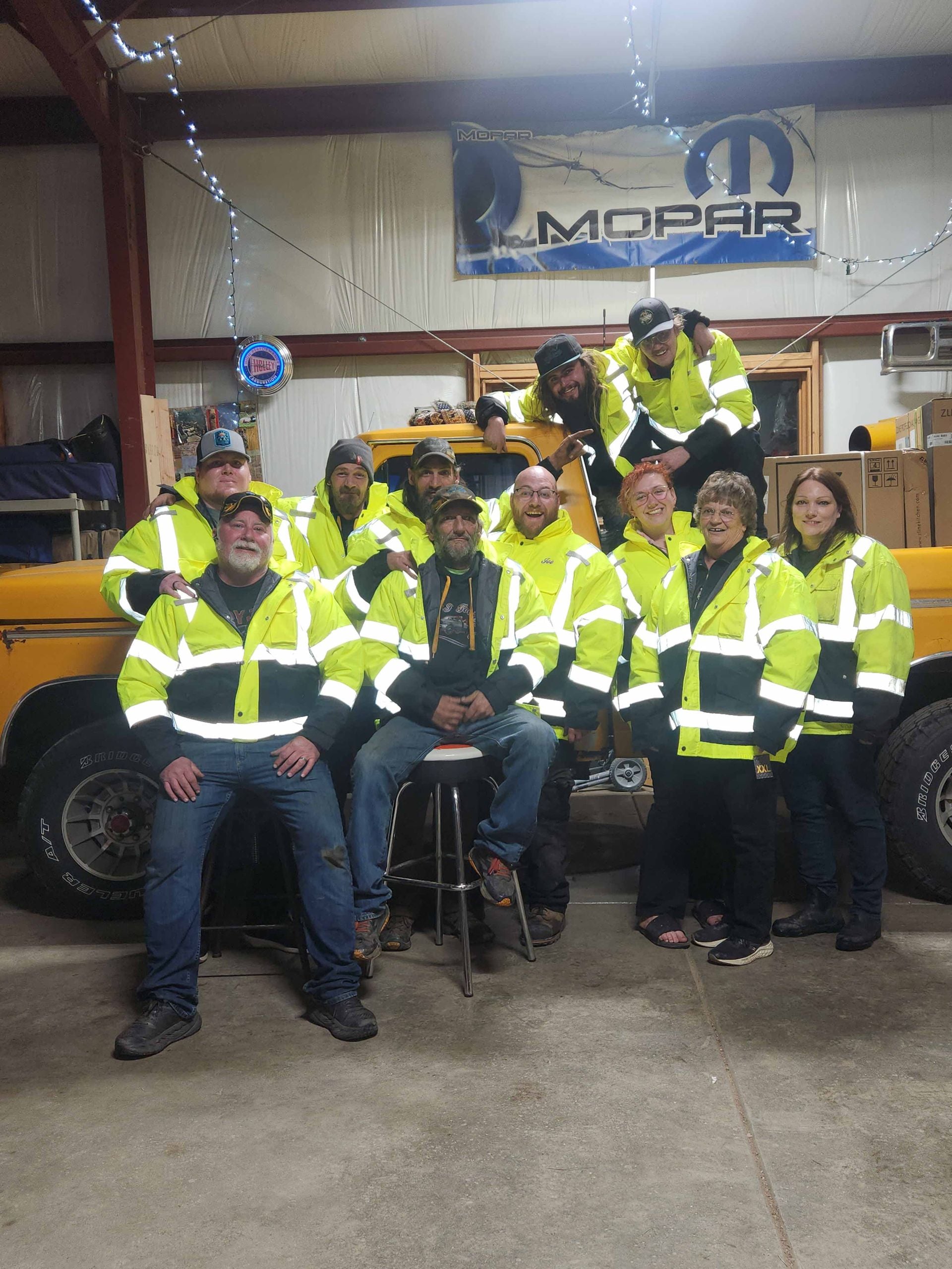 The D&J Towing crew in high-visibility jackets in front of a tow truck