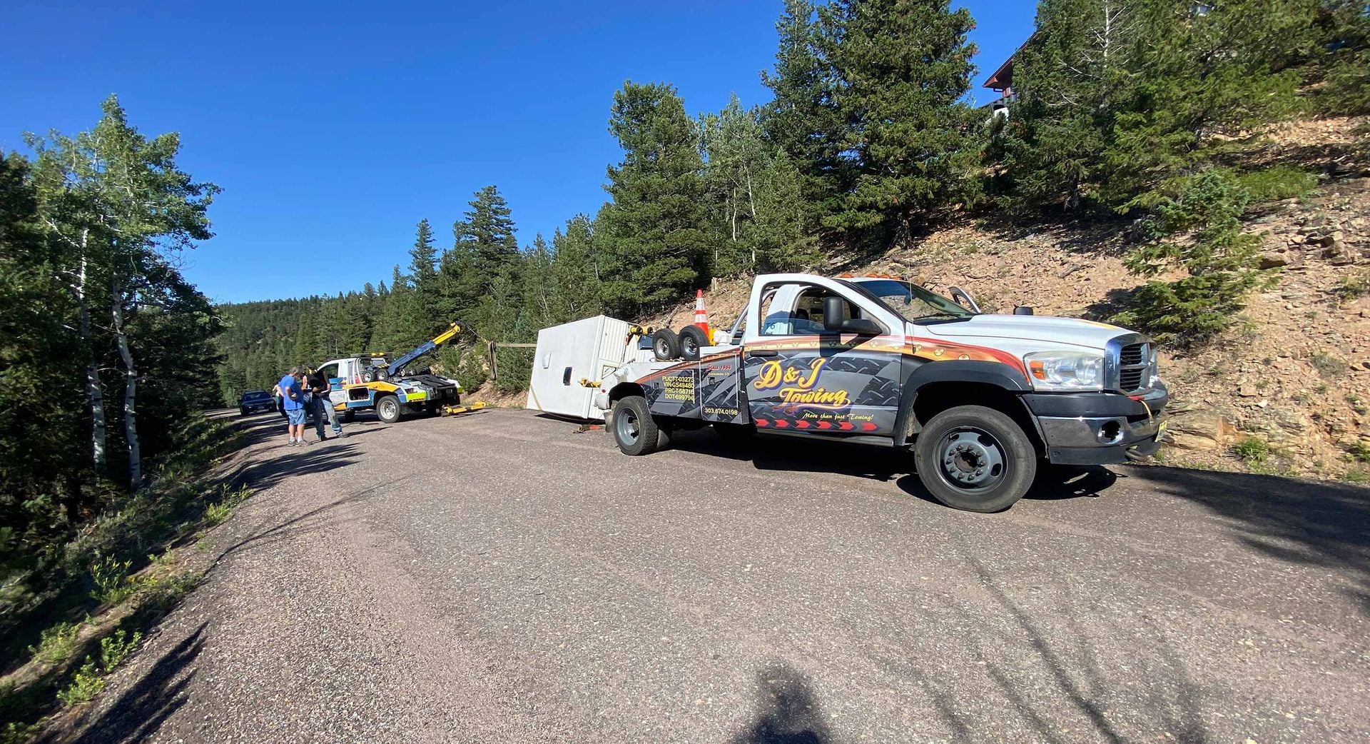 D&J Towing wrecker working a vehicle recovery at a mountain pull-off
